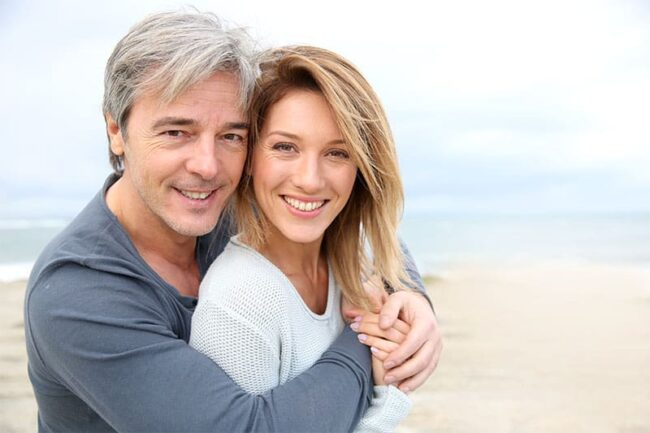 Smiling older couple enjoying life after full arch dental implant treatment